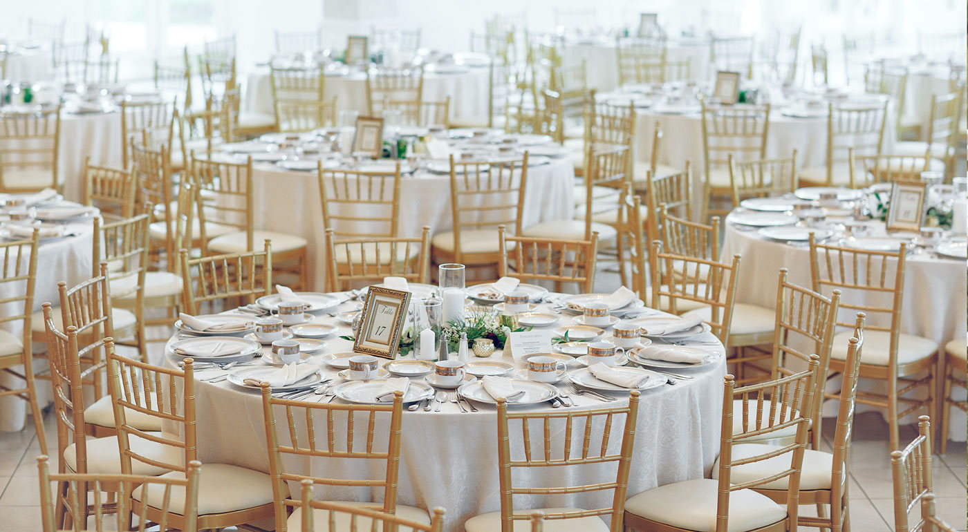 Großer Saal mit eingedeckten Tischen für eine unvergessliche Hochzeitsfeier.